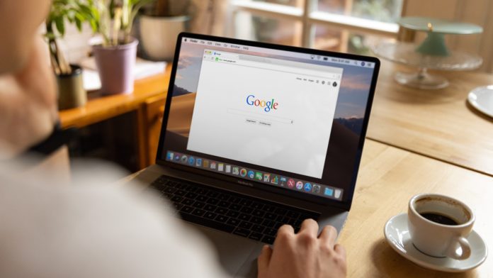 person using macbook pro on table