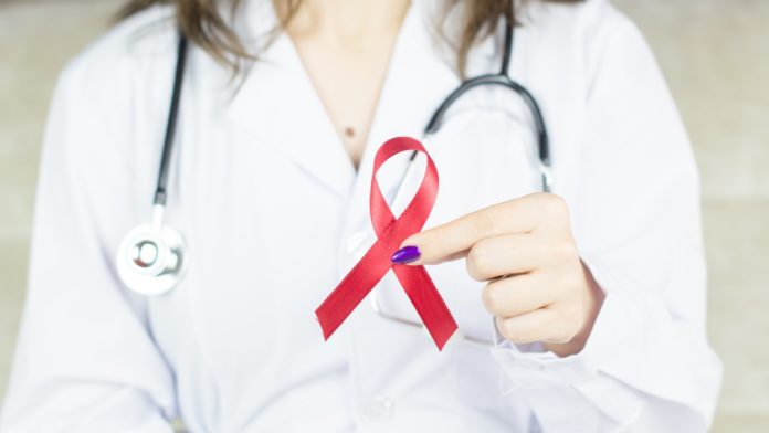 a woman in a white shirt holding a red ribbon