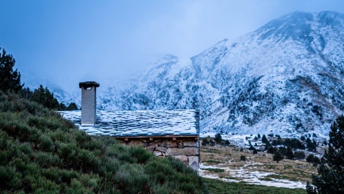 white and brown house near mountain under blue sky during daytime