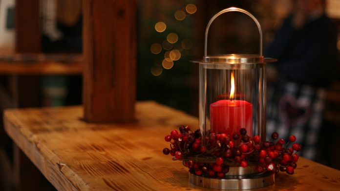 red lighted candle on brown wooden frame