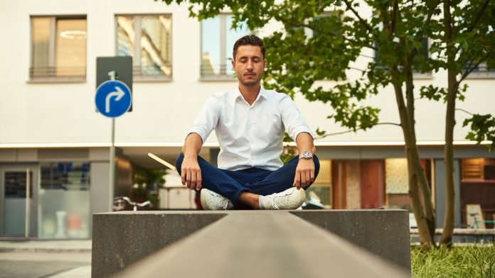man in white dress shirt sitting on gray concrete bench during daytime