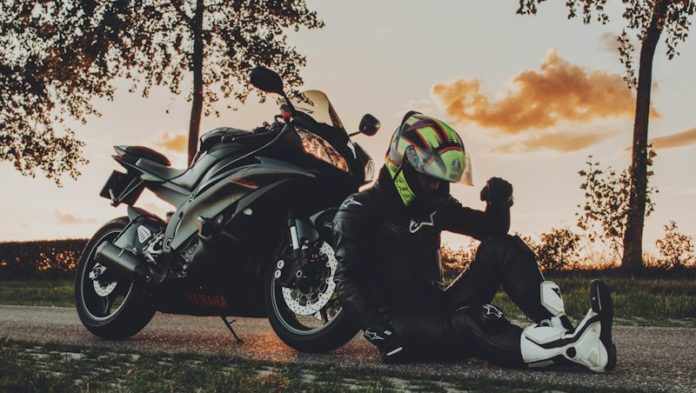 2 men riding sports bike on green grass field during sunset